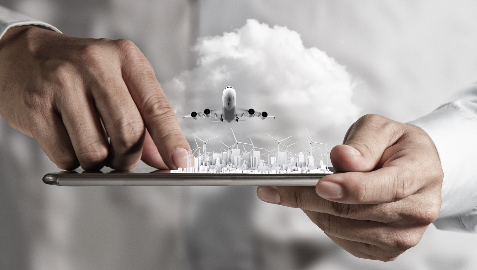 a plane flying over a city with windmills that is held on a tablet