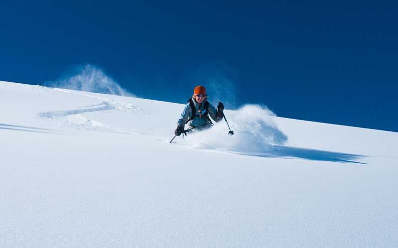 A woman is skiing down the slopes in Aspen Colorado