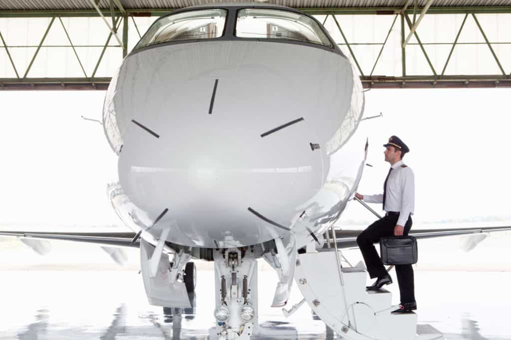 a pilot entering a plane in a hangar