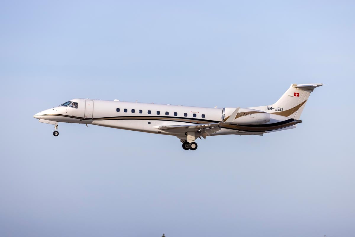 An Embraer Legacy private jet flying through the air