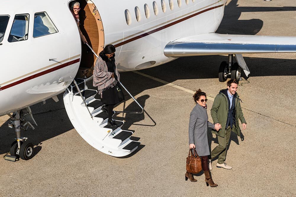 Business people embarking from private jet