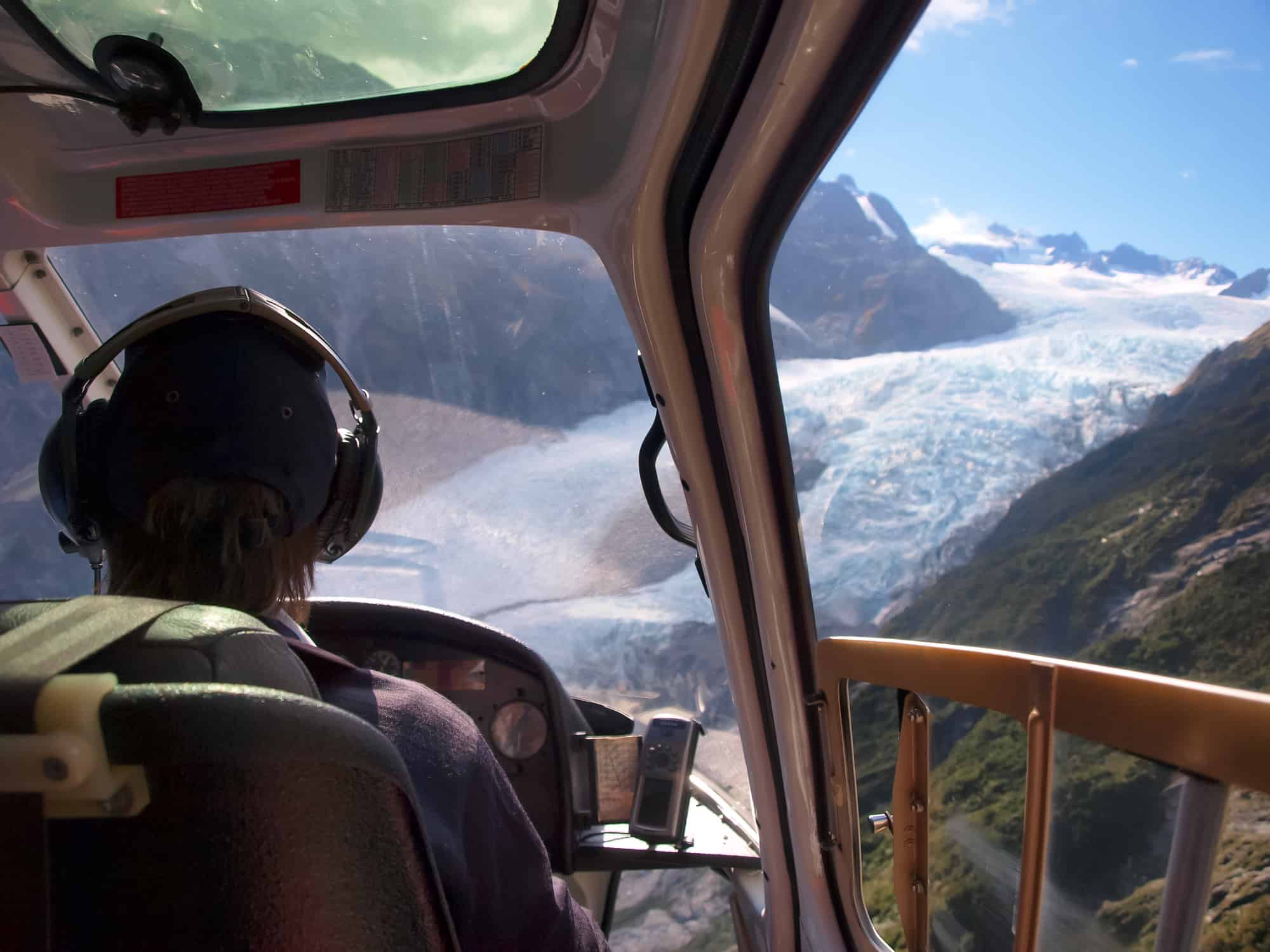 A helicopter pilot flying through mountains