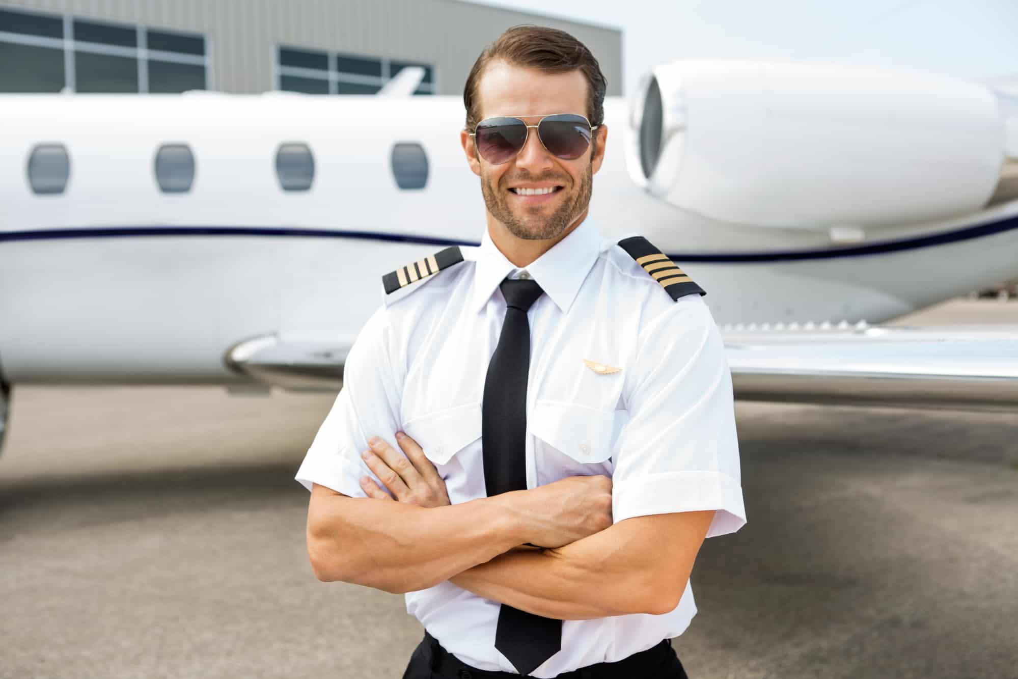 A private jet pilot standing in front of a private jet