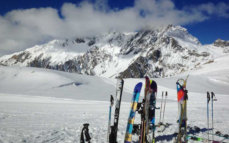 Snowboards and skis are stuck in the snow at mountains of St Anton am Arlberg