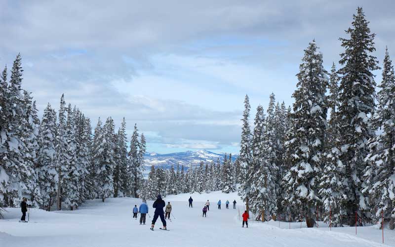 People are standing at the mountains of Steam Boat Springs