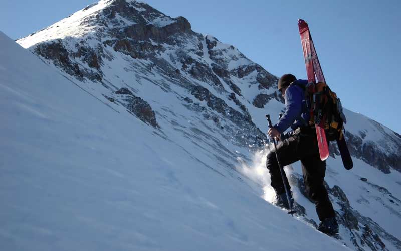 A man is walking up the slopes of Telluride Colorado